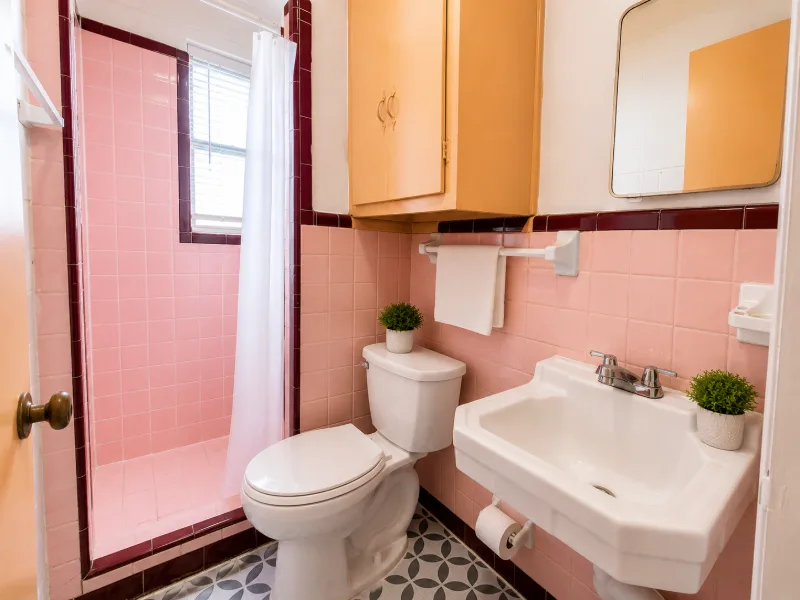 Bathroom with pink tile, shower, toilet, and sink