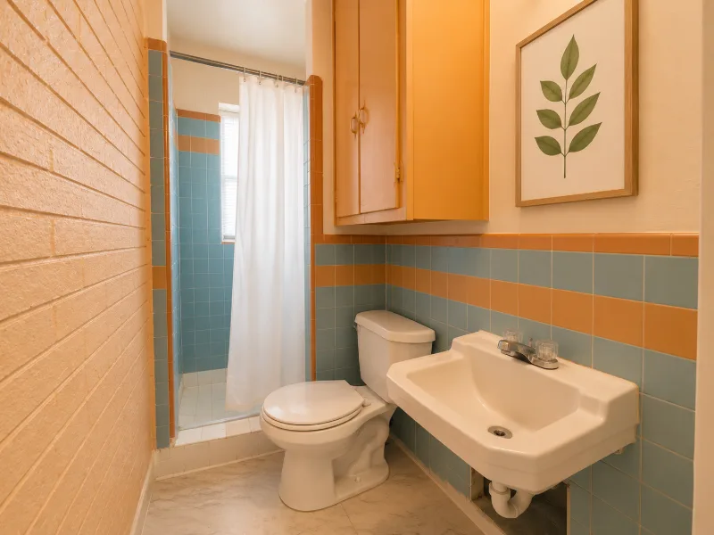 Bathroom with blue and orange striped tile and a shower curtain