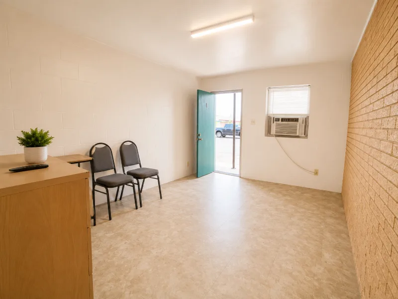 Leasing office waiting area with chairs and the front door open to the parking lot