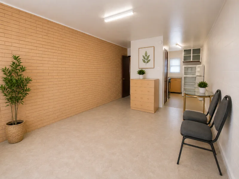 Efficiency main room with a tan brick accent wall and sitting area