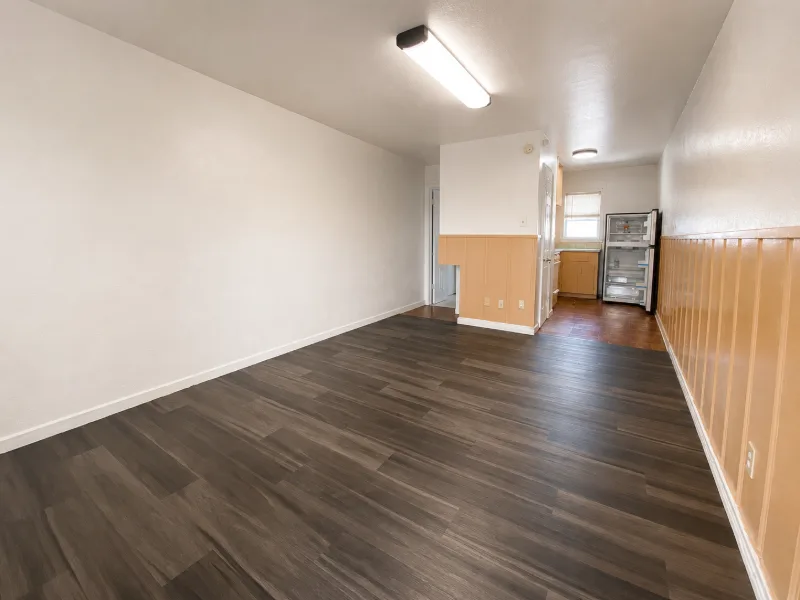 Efficiency main room with dark wood floor and a wall air conditioner